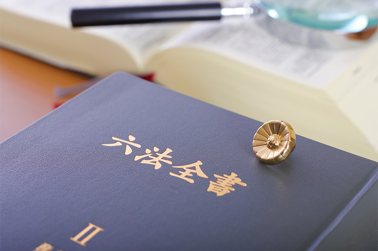 六法全書と弁護士バッチ