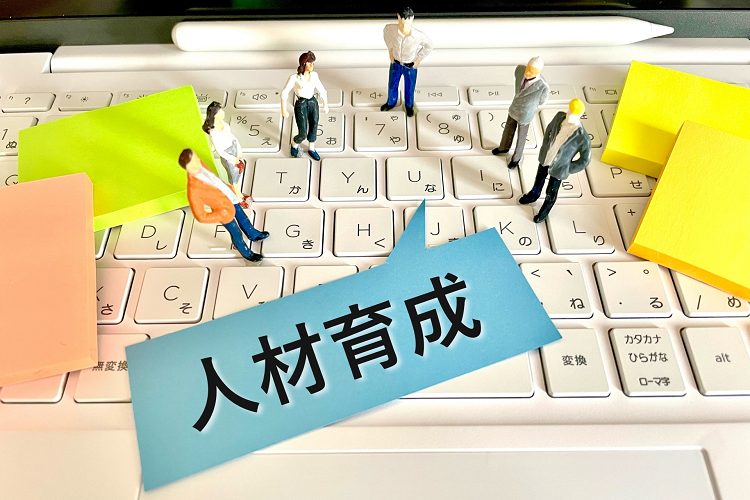 キーボードの上にビジネスマンのミニチュア達と人材育成の文字