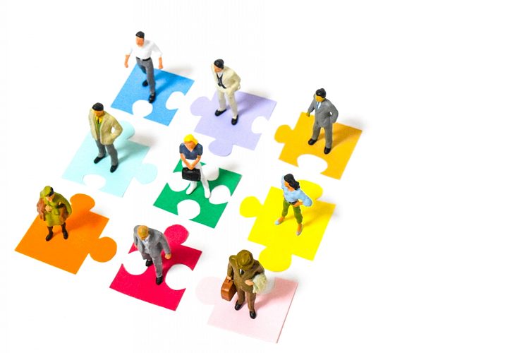 様々な色のパズルピースとその上に様々な人