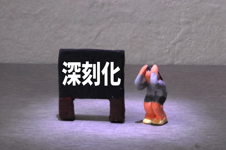 深刻化の文字と頭を抱える女性のミニチュア